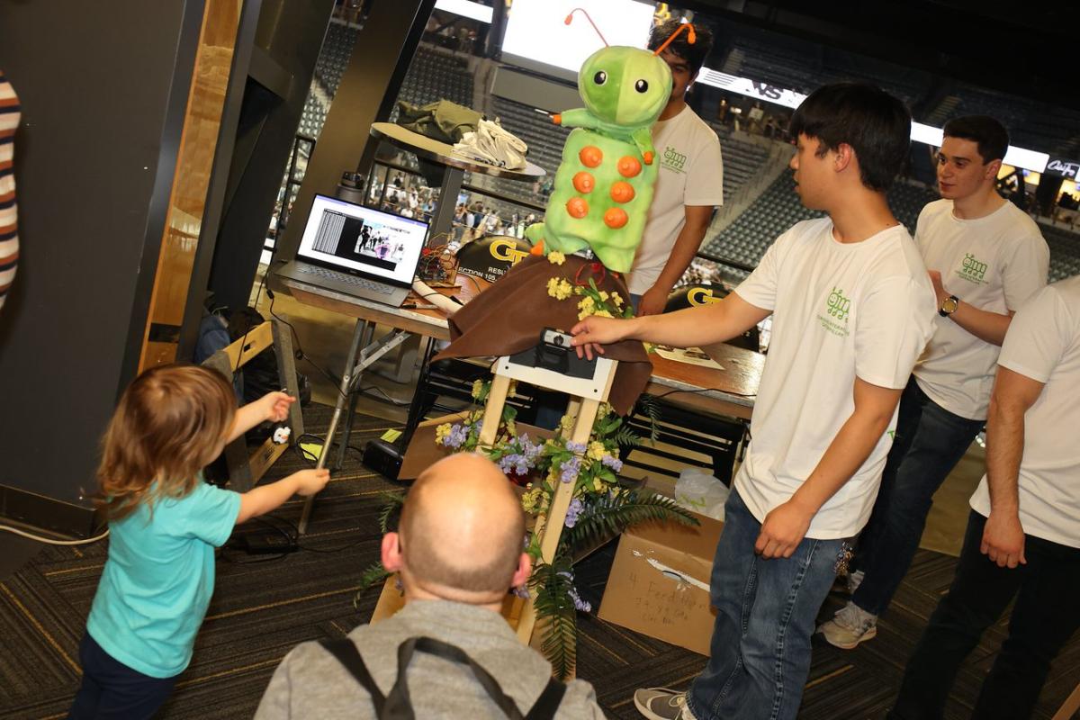 a child interacts with a caterpillar robot from a Capstone project