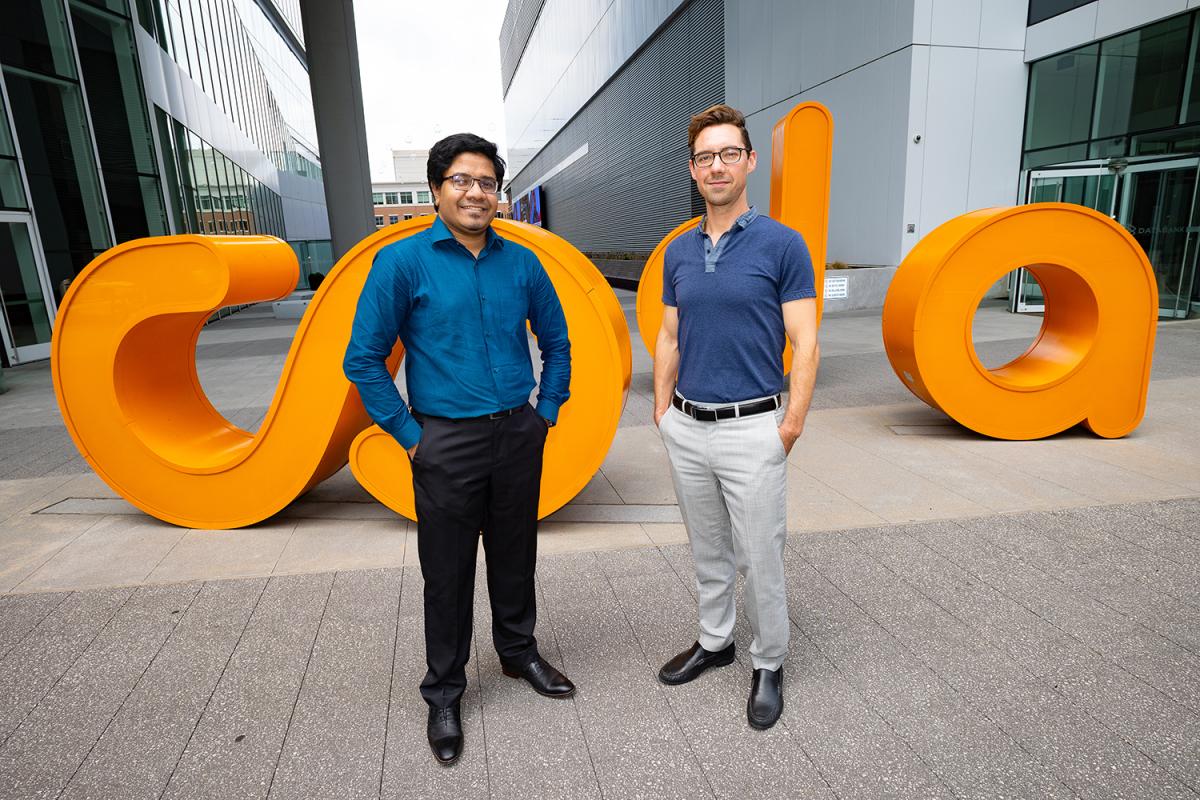 Amit Sikder and Brendan Saltaformaggio in front of the orange CODA letters outside the CODA Building in Midtown Atlanta. (Photo: Candler Hobbs)