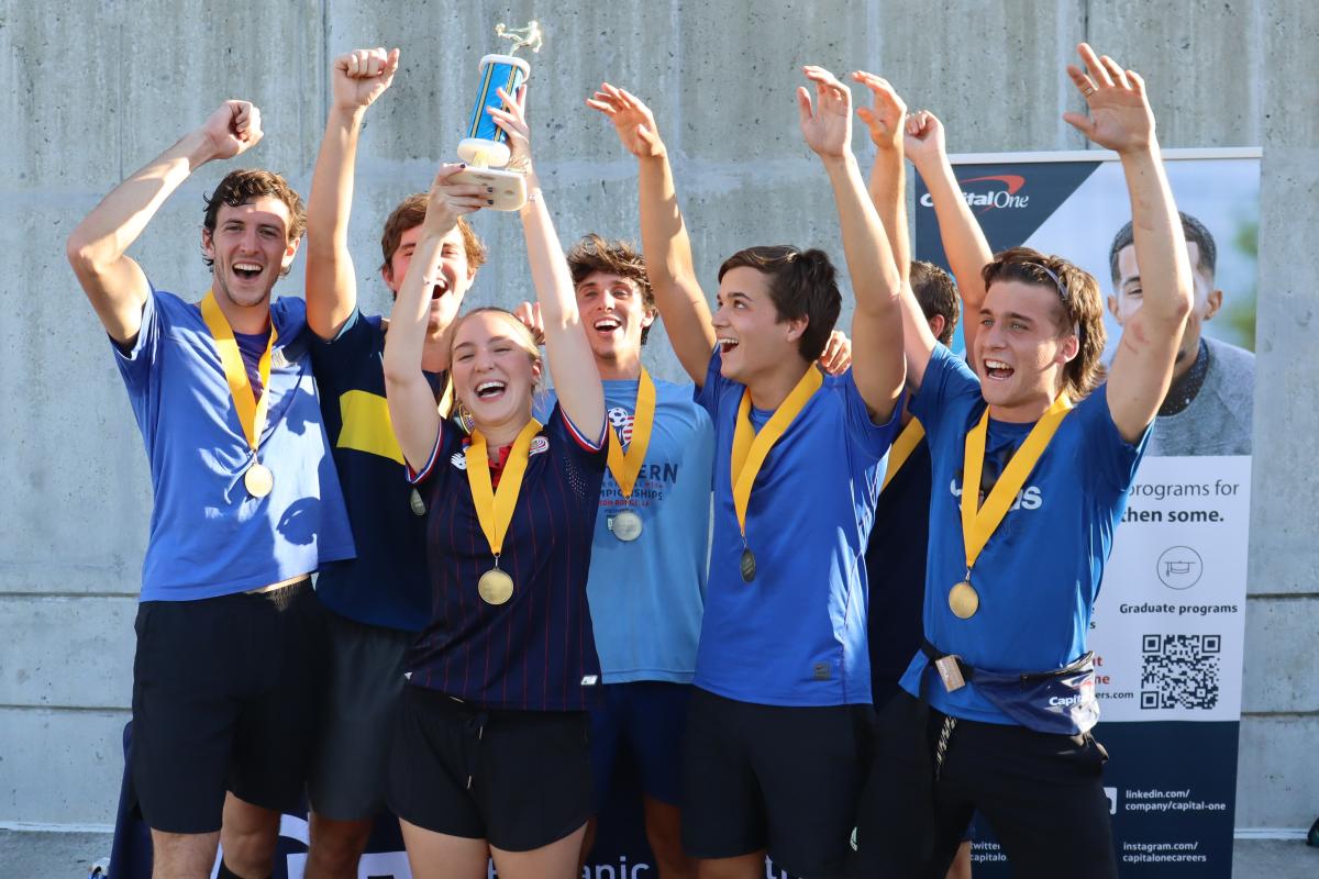 students celebrating and holding a scocer trophy