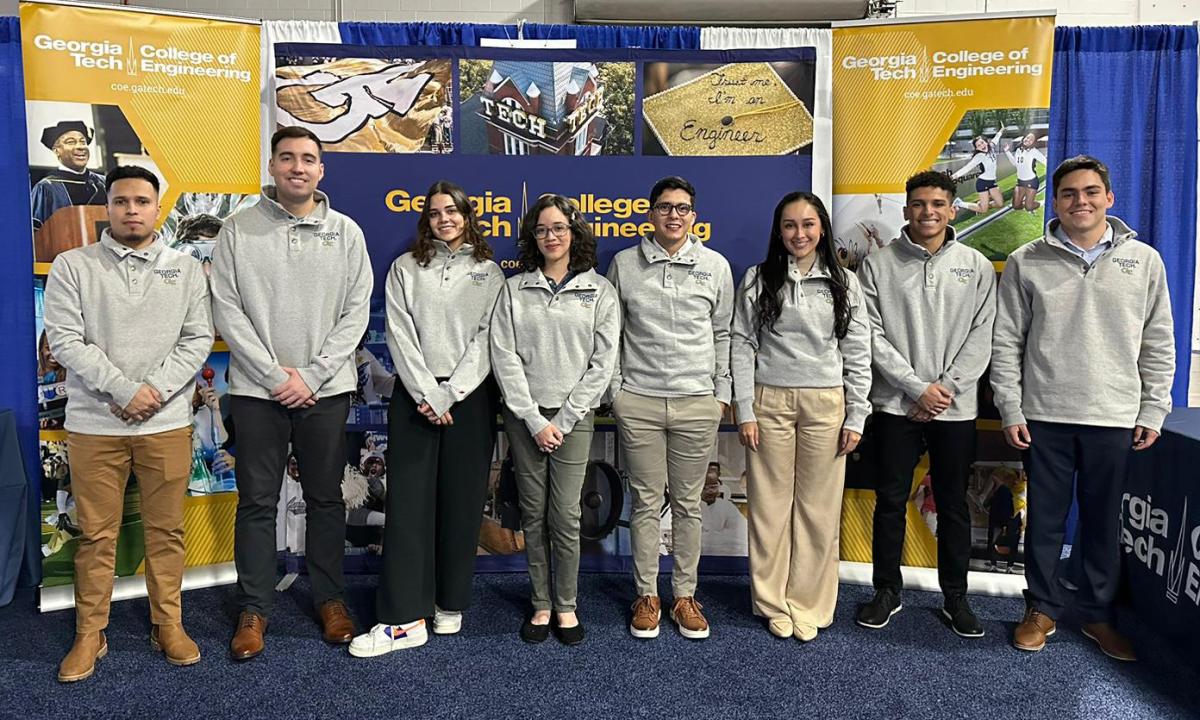 Nicole Proudfoot and other CEED students at a conference booth