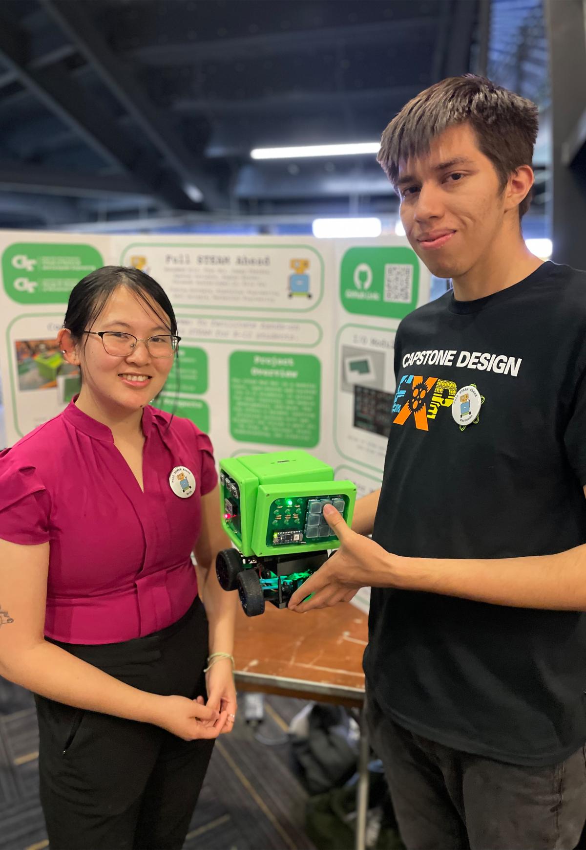 two students holding a small cube