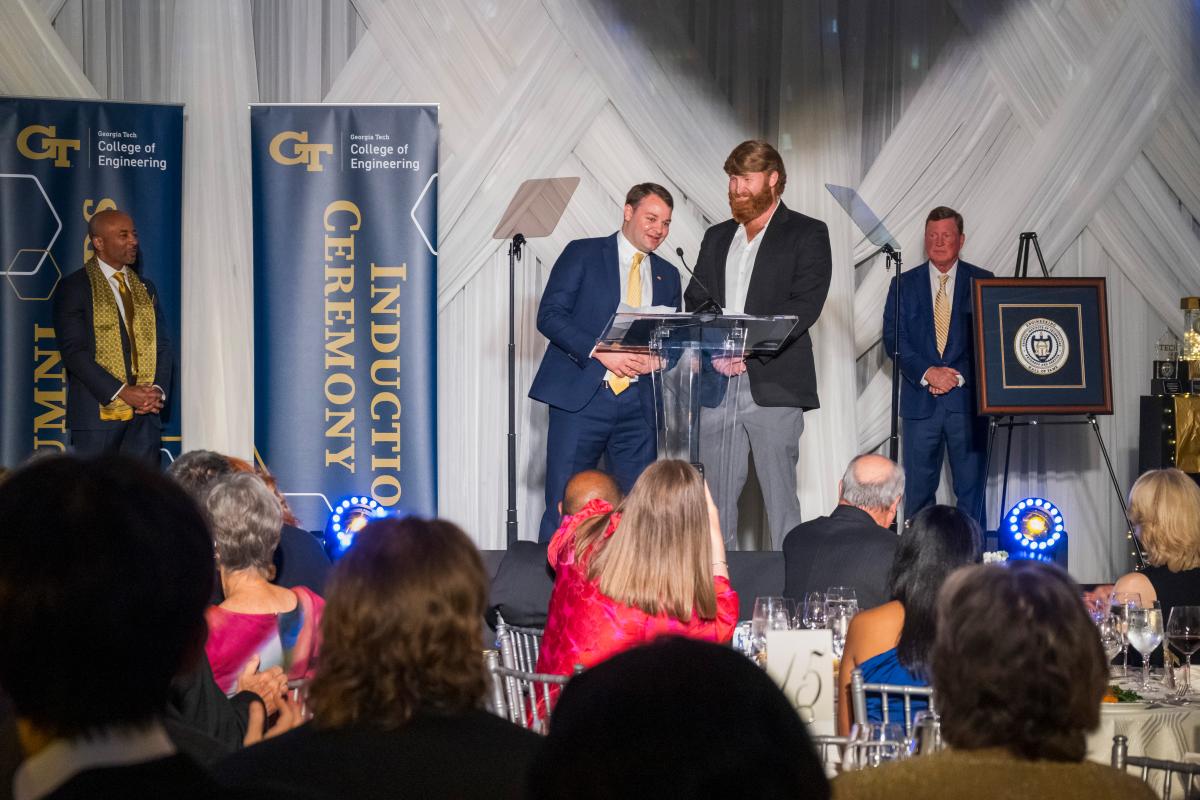 two people accept award on stage