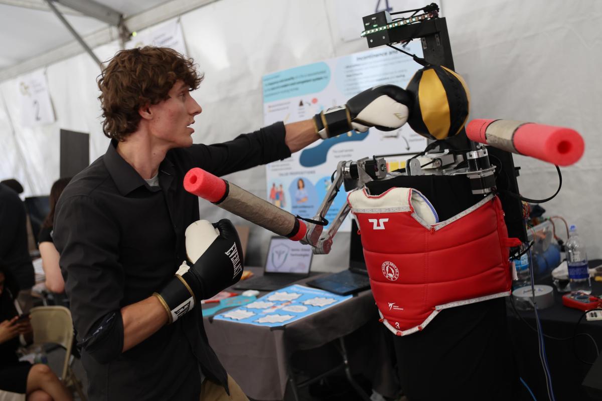 student punches around a robot