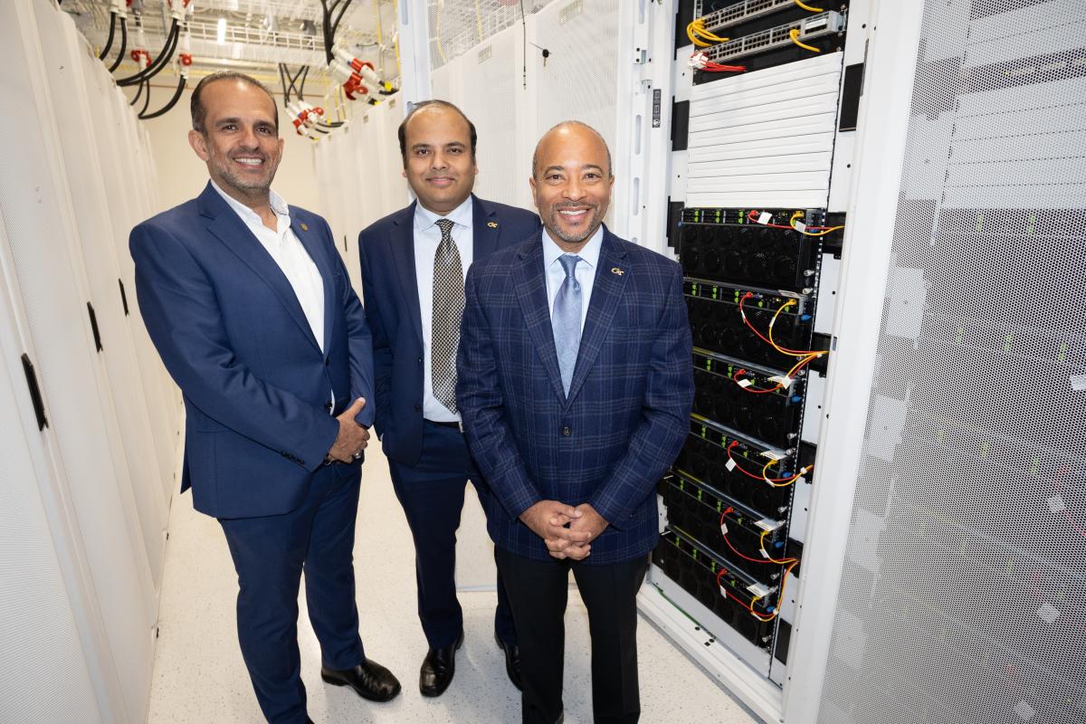 Three people standing in a server room