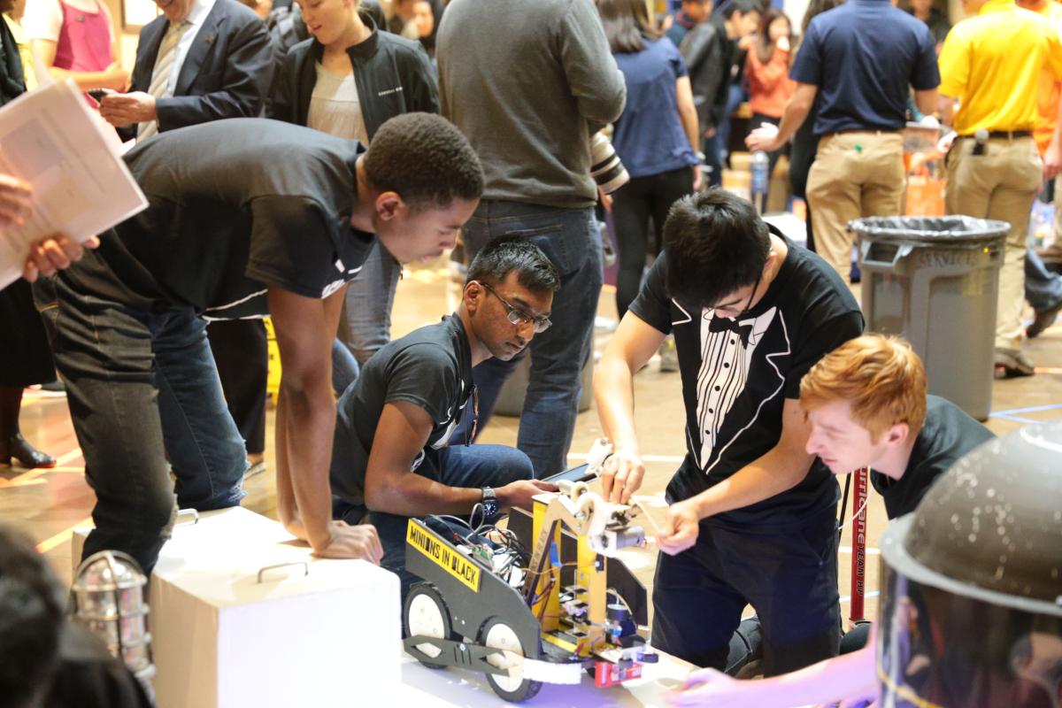 Students gathered around their project amidst a crowd at the ME2110 sophomore design showcase.