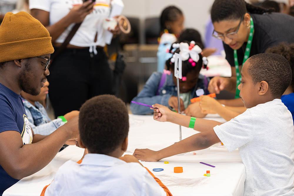 students making stuff at a table for stem fest