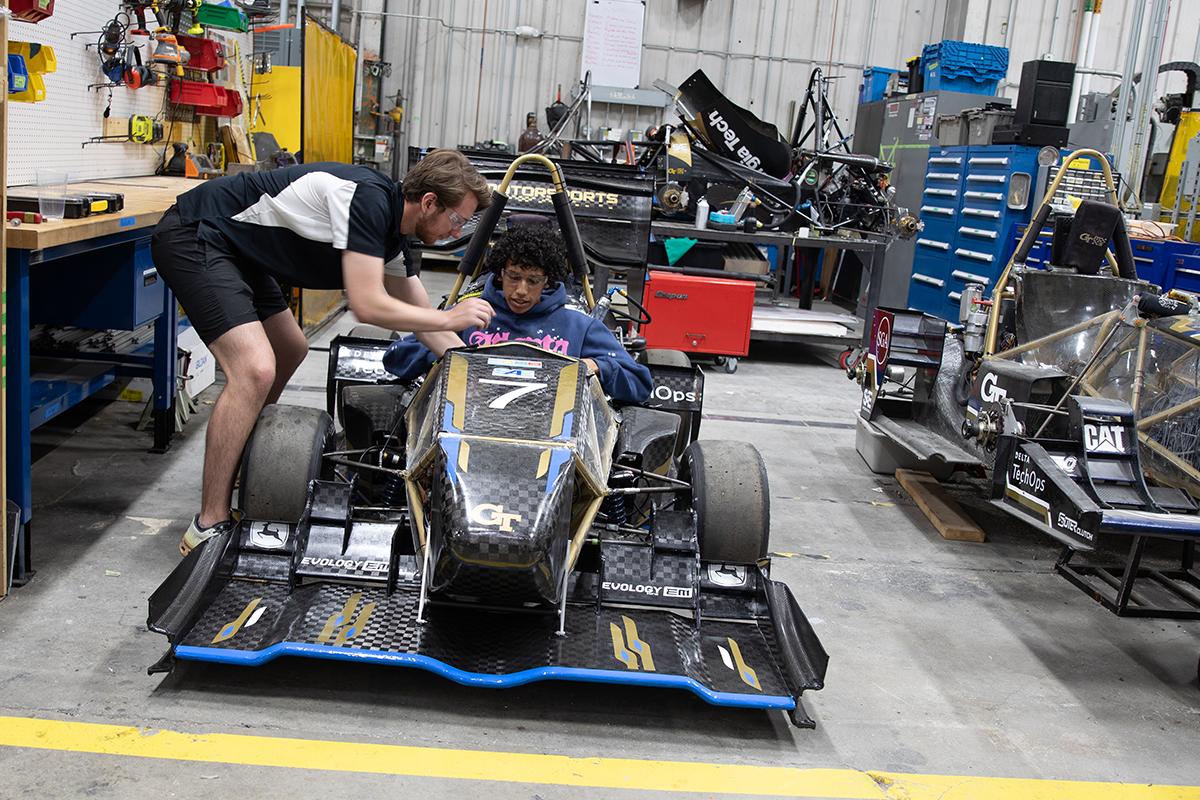 two students work on a car in the student competition center