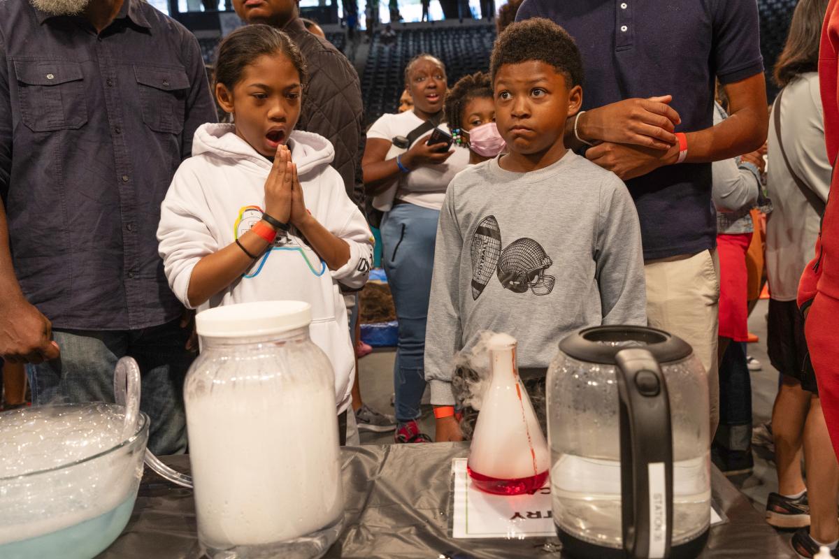 students with surprised look while looking at experiment