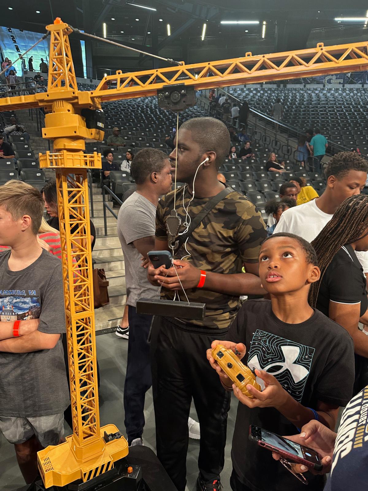 student uses remote control to control crane