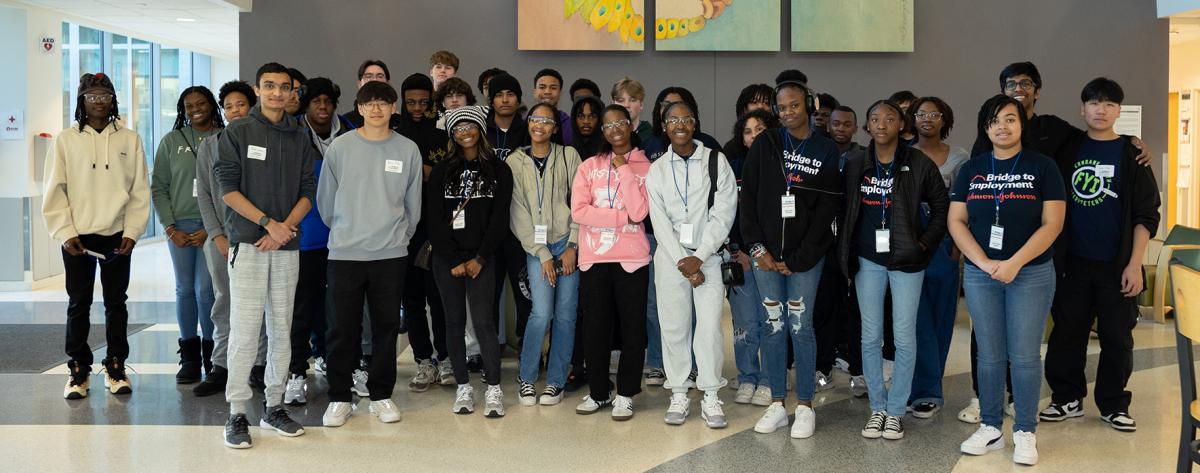 Group photo of Bridge to Employment participants in a building atrium