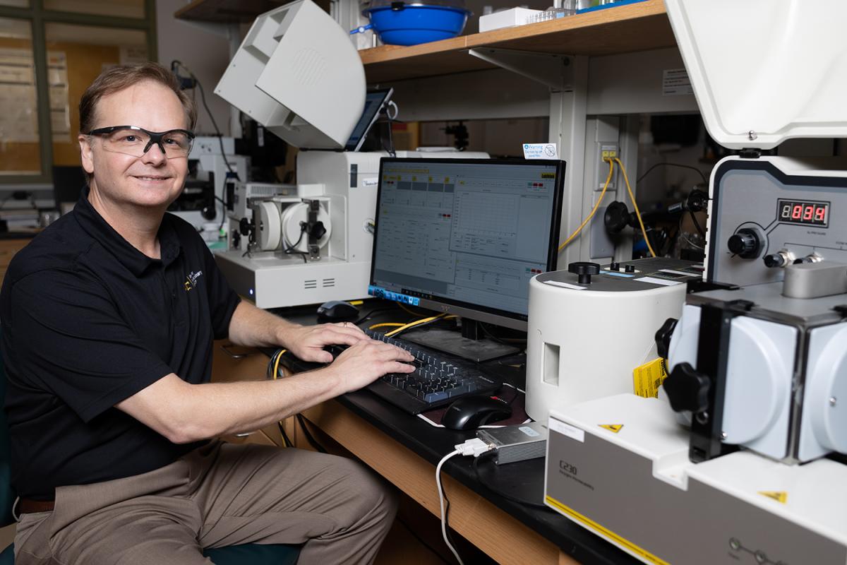 Carson Meredith sits at a computer in the lab