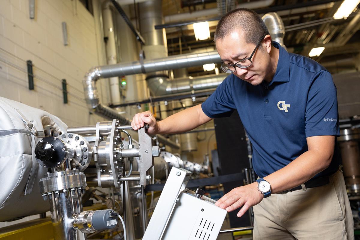 Wenting Sun adjusts equipment in the Zinn Combustion Lab