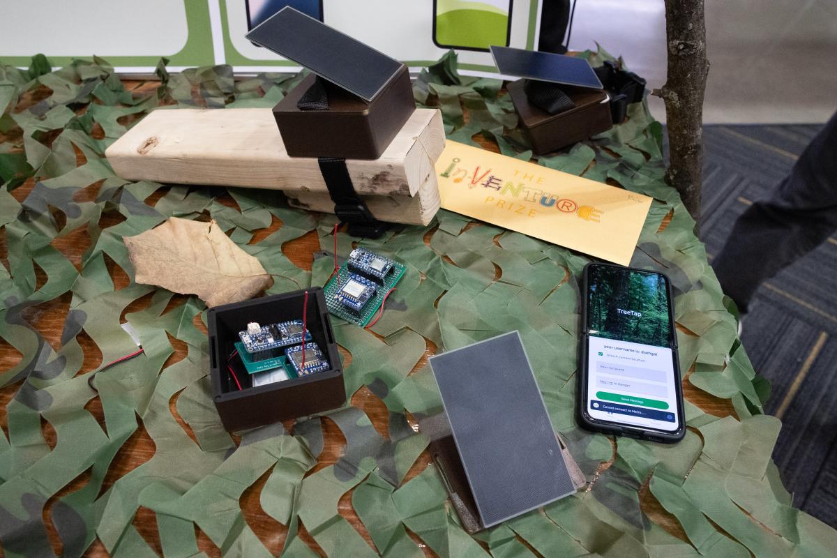 devices on a table atop green material that looks like tree leaves