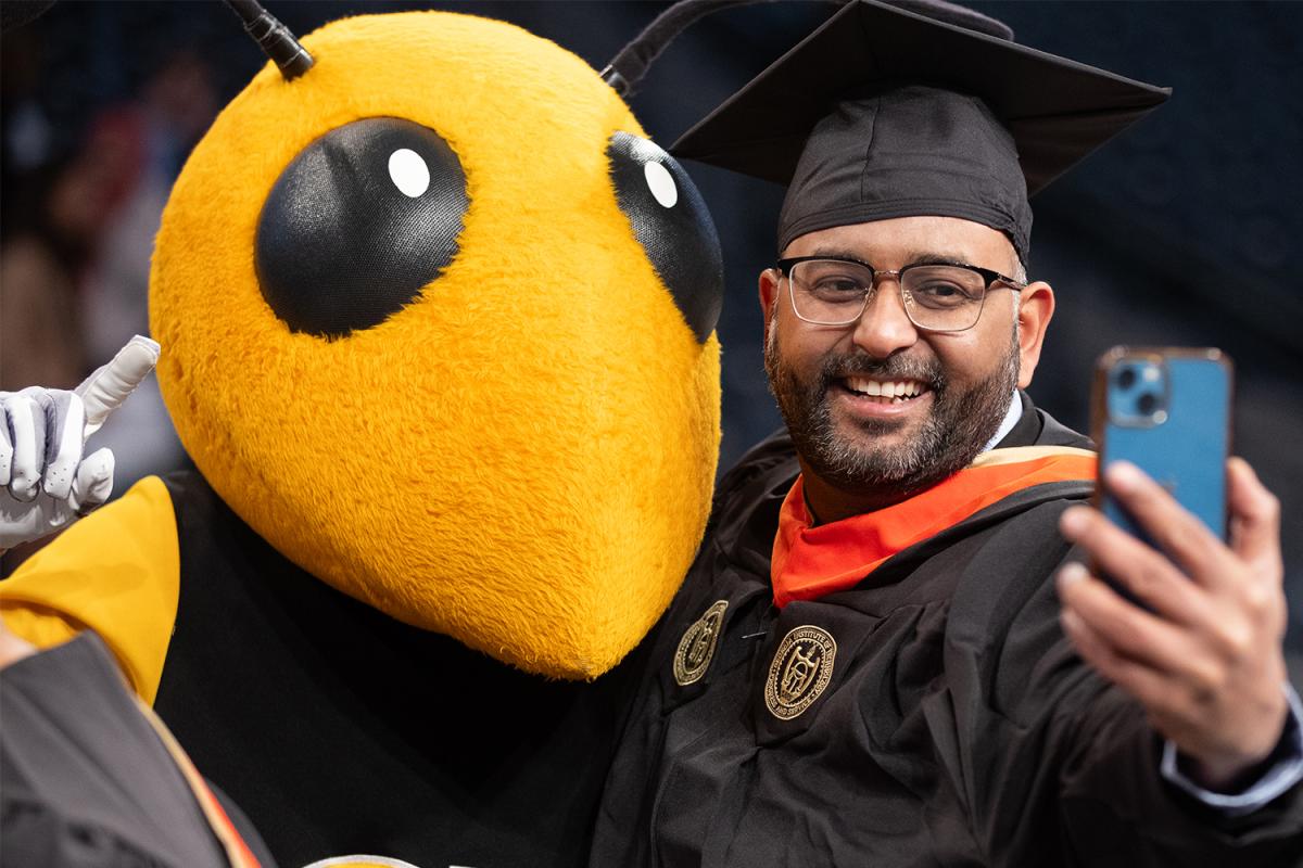 An engineering master's graduate takes a selfie with Buzz