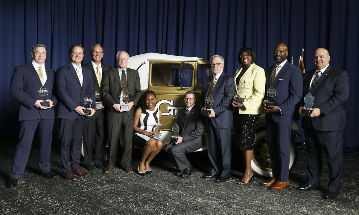 a group of people holding awards stand with the Ramblin' Wreck 