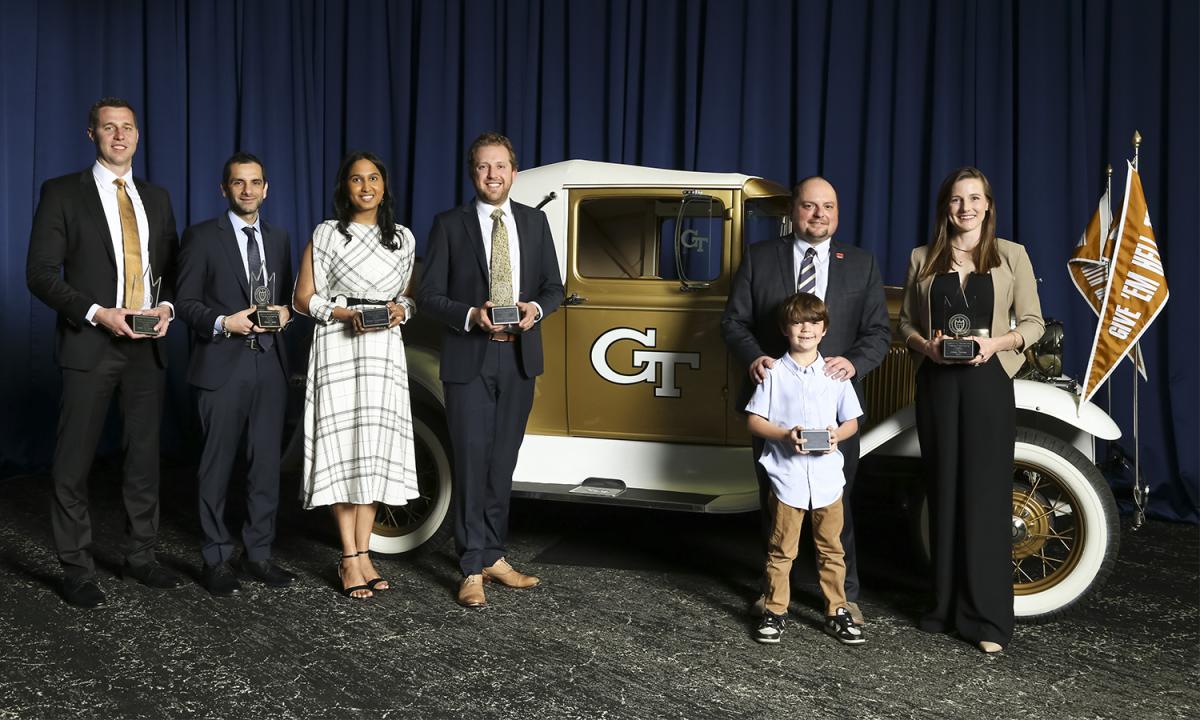 a group of people holding awards stand with the Ramblin' Wreck