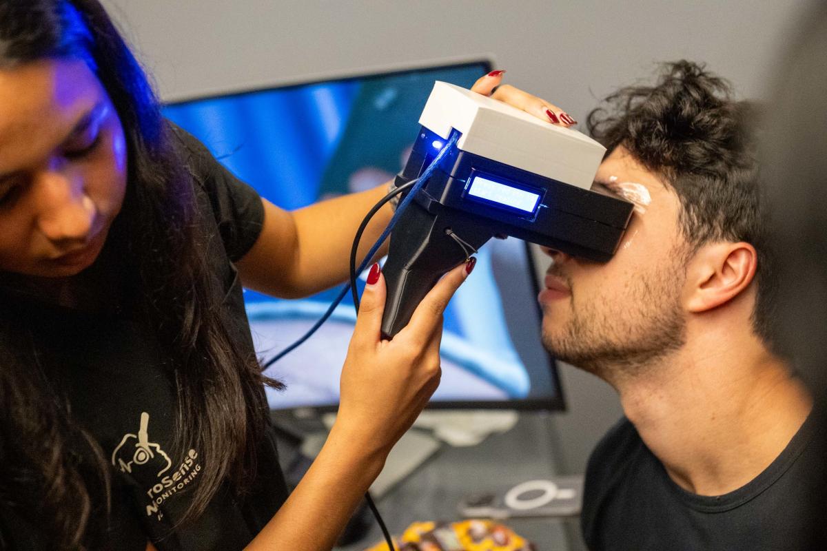 a person holding an ocular device to another person's eyes