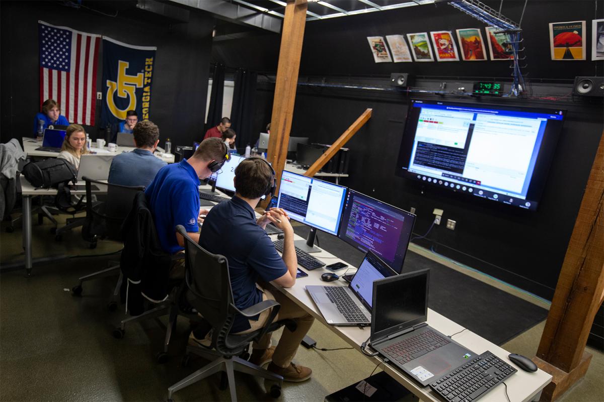 people at computers in a mission control room