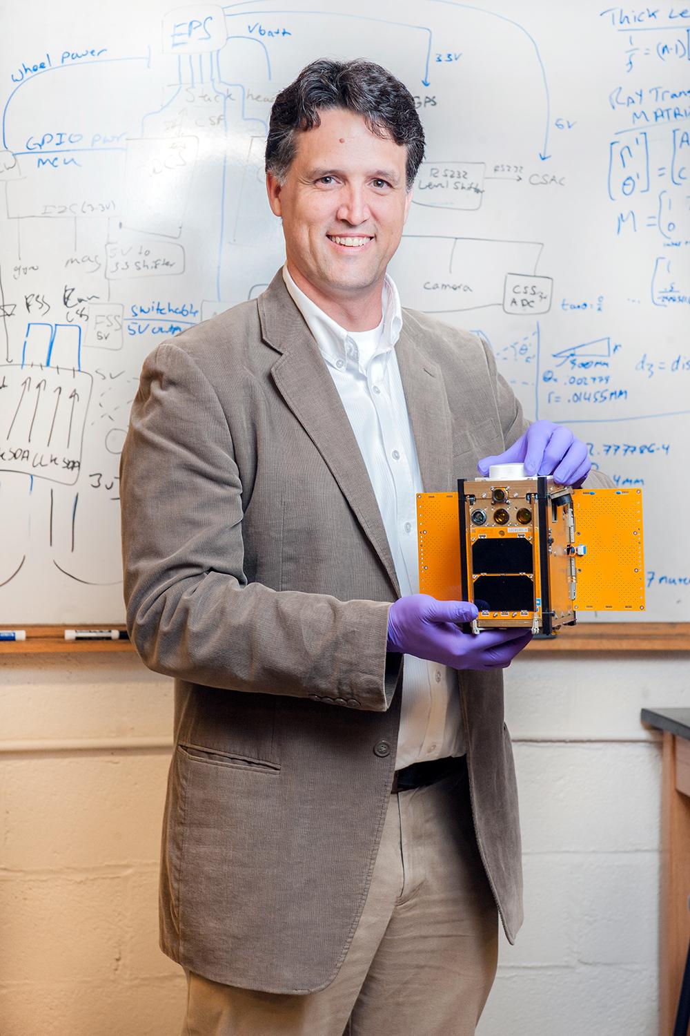 Brian Gunter holds a CubeSat