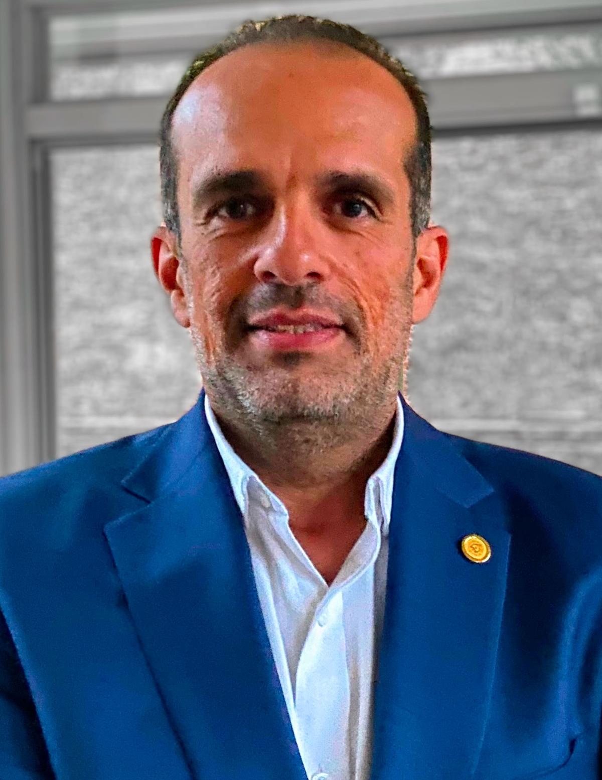 Ghassan AlRegib looking at camera wearing white shirt and blue jacket