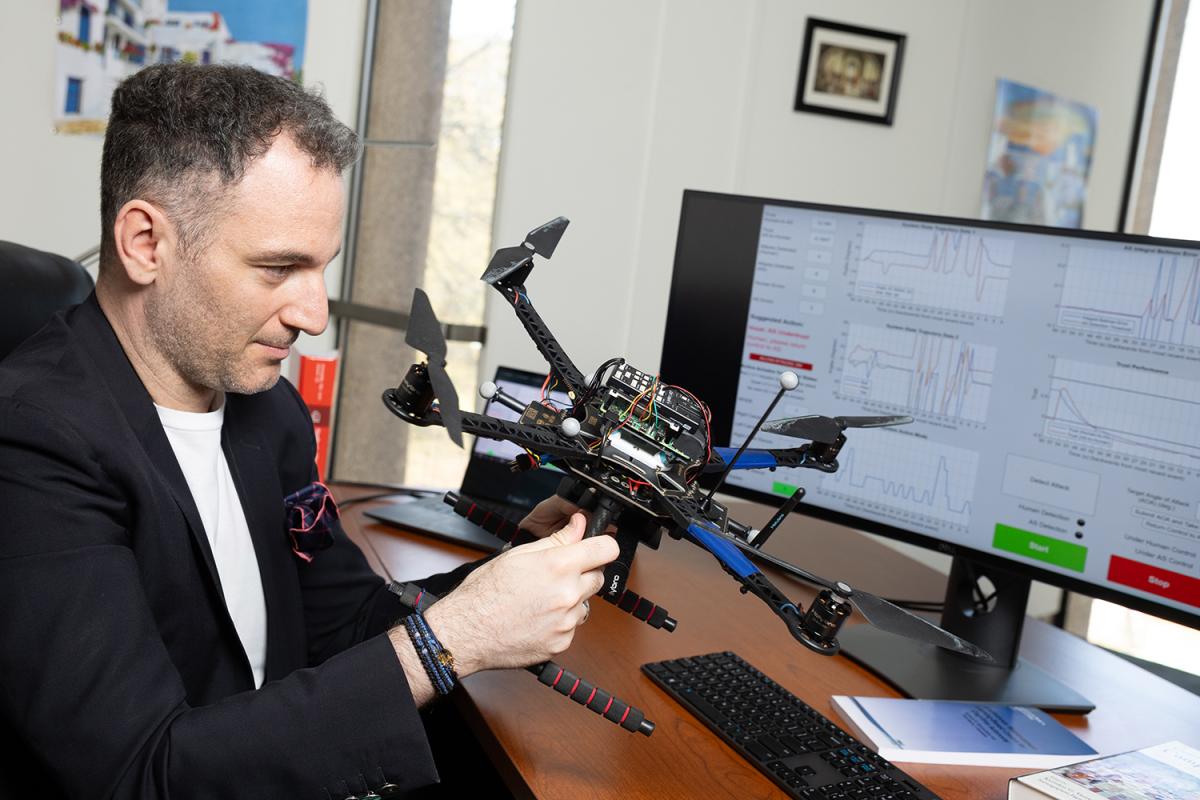 Kyriakos Vamvoudakis works with a drone next to a computer