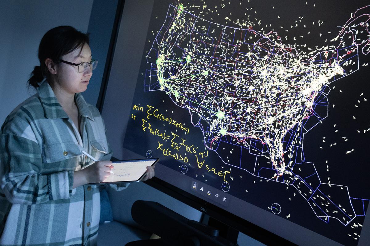 Sarah Li in front of an air traffic map