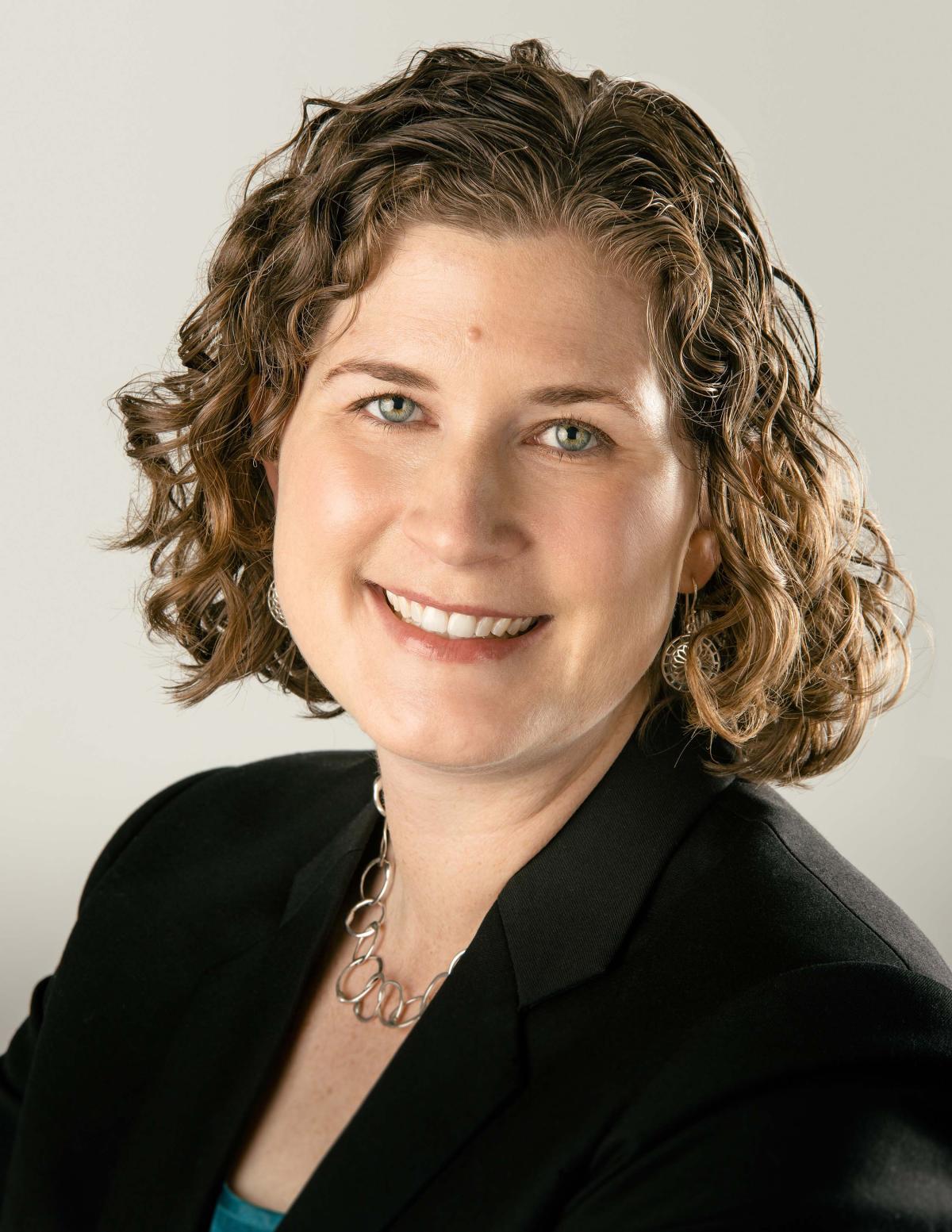 Karen Feigh looking at the camera, wearing black coat