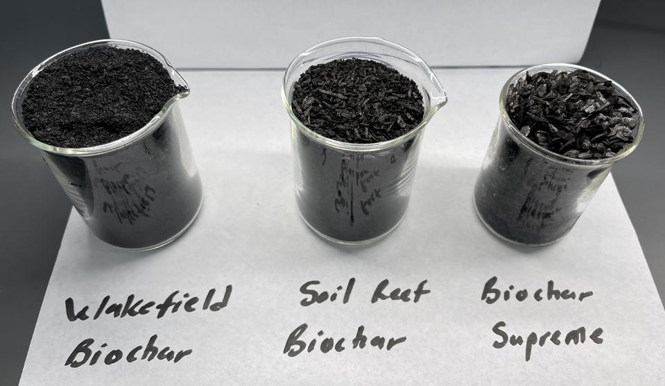 three beakers containing samples of a biological charcoal material