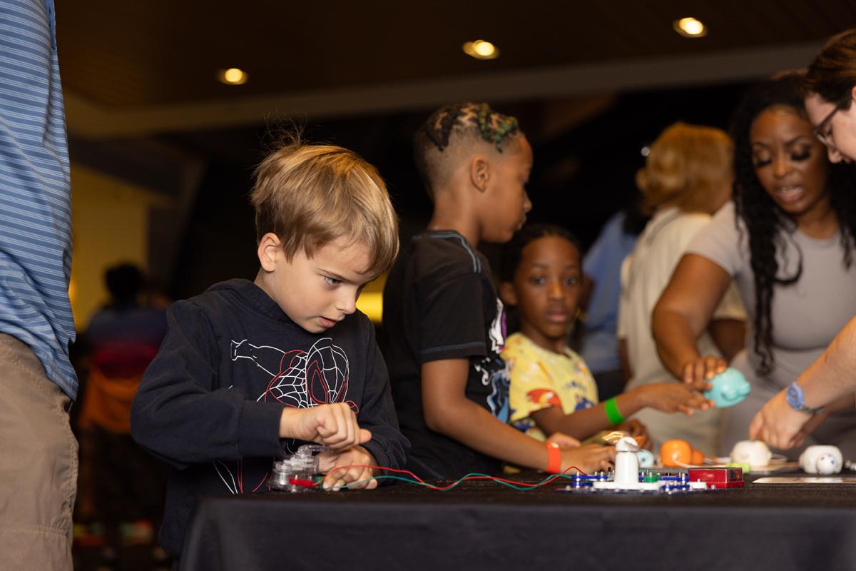 A young student concentrates on building circuits.