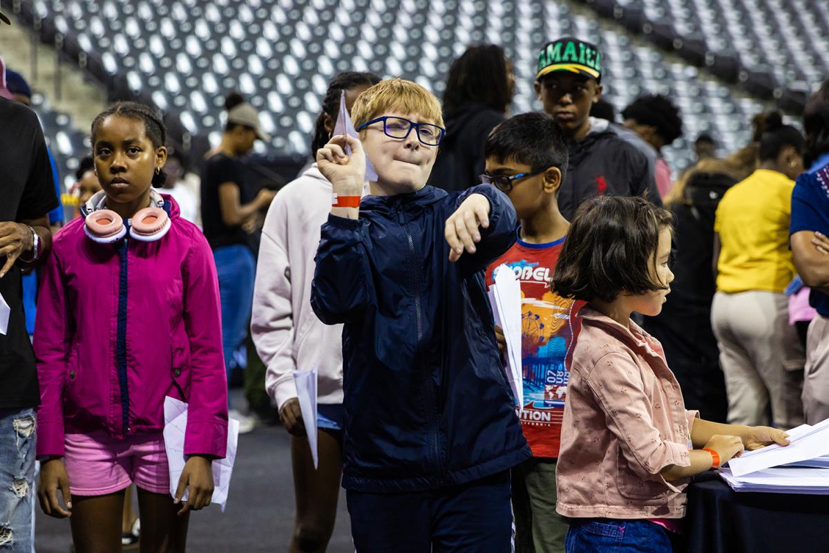 A student takes aim with a paper airplane at STEM Fest.