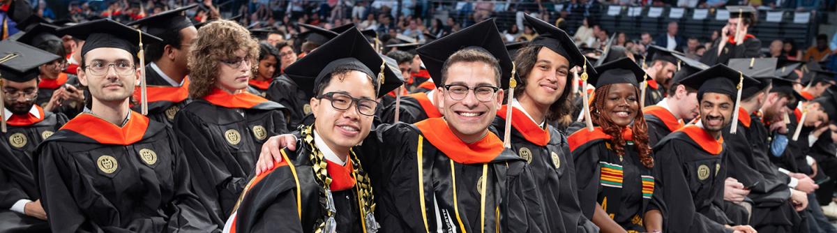 grads posing for camera at ceremony