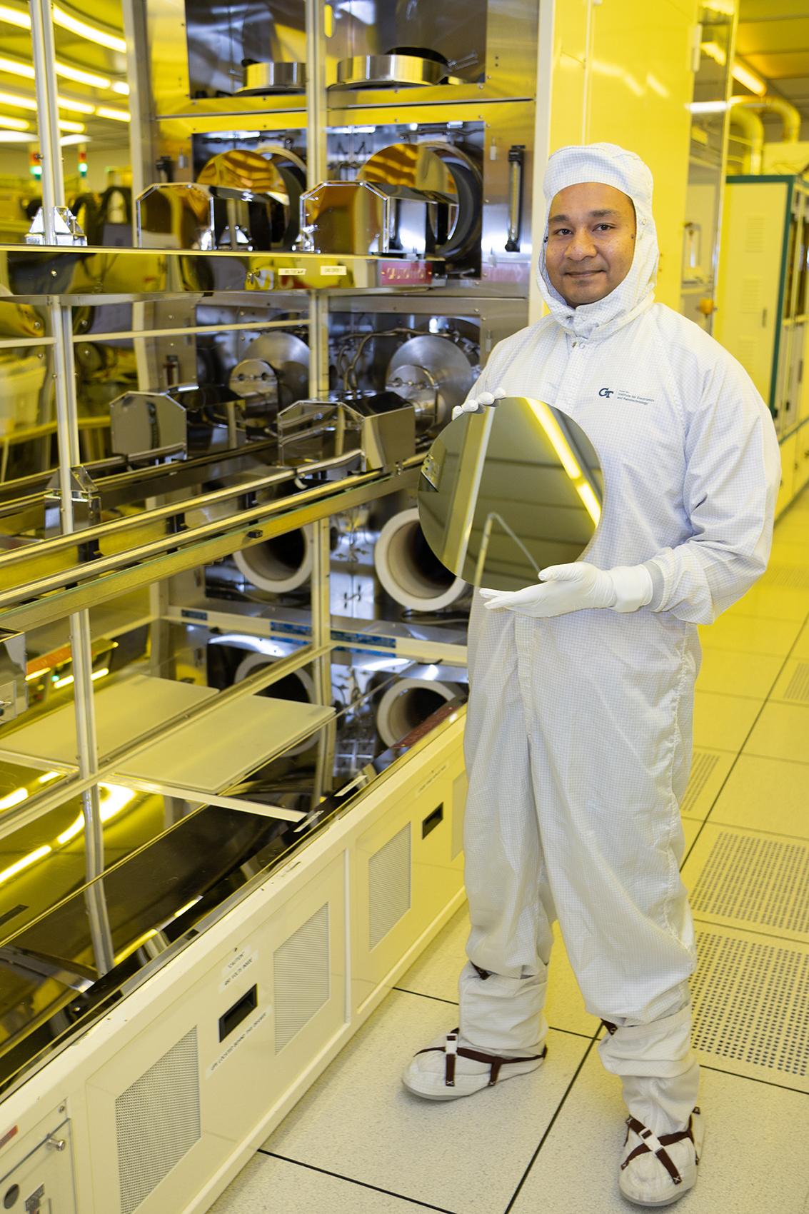 asif khan holds a silicon wafer in a cleanroom