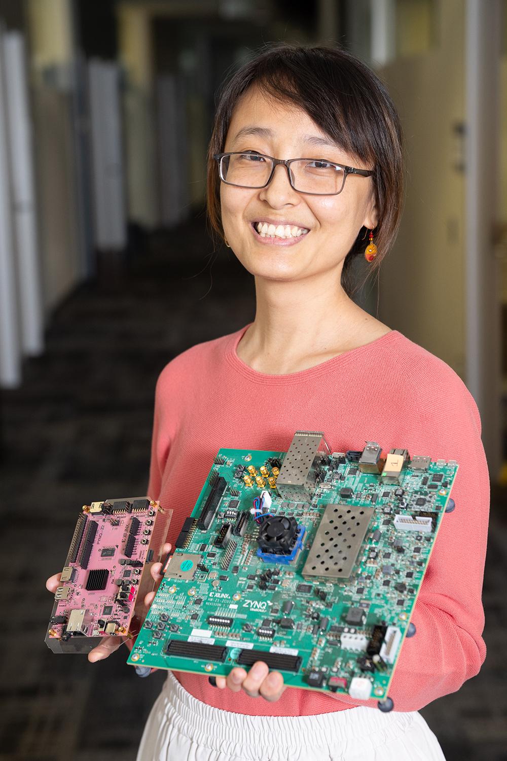 a person holding two computing circuitboards