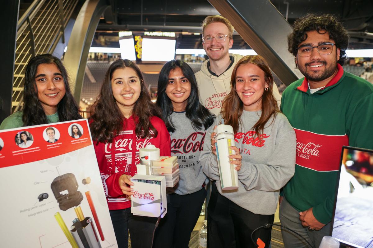 group of people wearing Coca-Cola gear holding drinking bottles