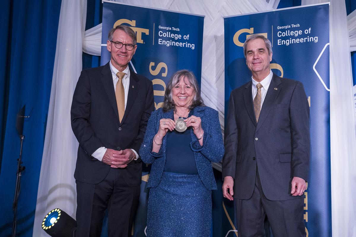 Gail Panarello Smith poses with her Engineering Hall of Fame medal alongside emcee Jim Borders and interim Dean Doug Williams.