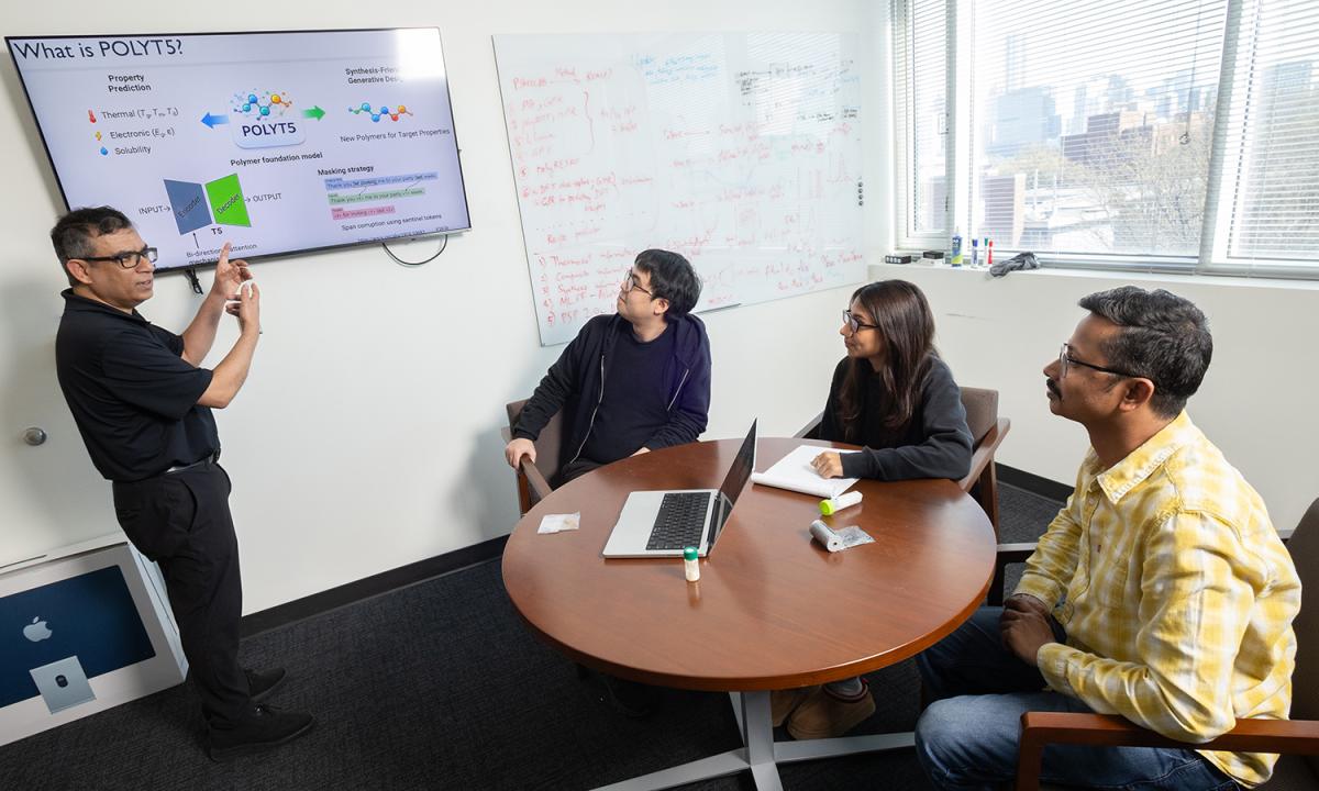 Rampi Ramprasad and three members of his research team discuss their AI models for generative polymer design in his office.