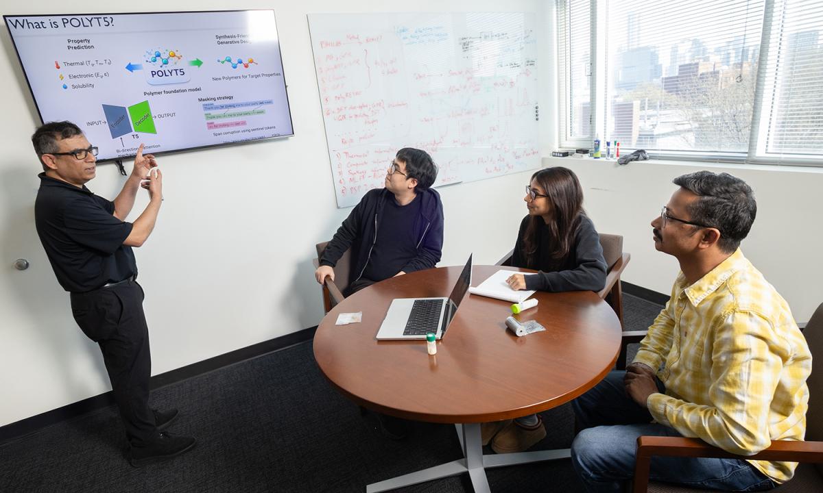 Rampi Ramprasad and three members of his research team discuss their AI models for generative polymer design in his office.