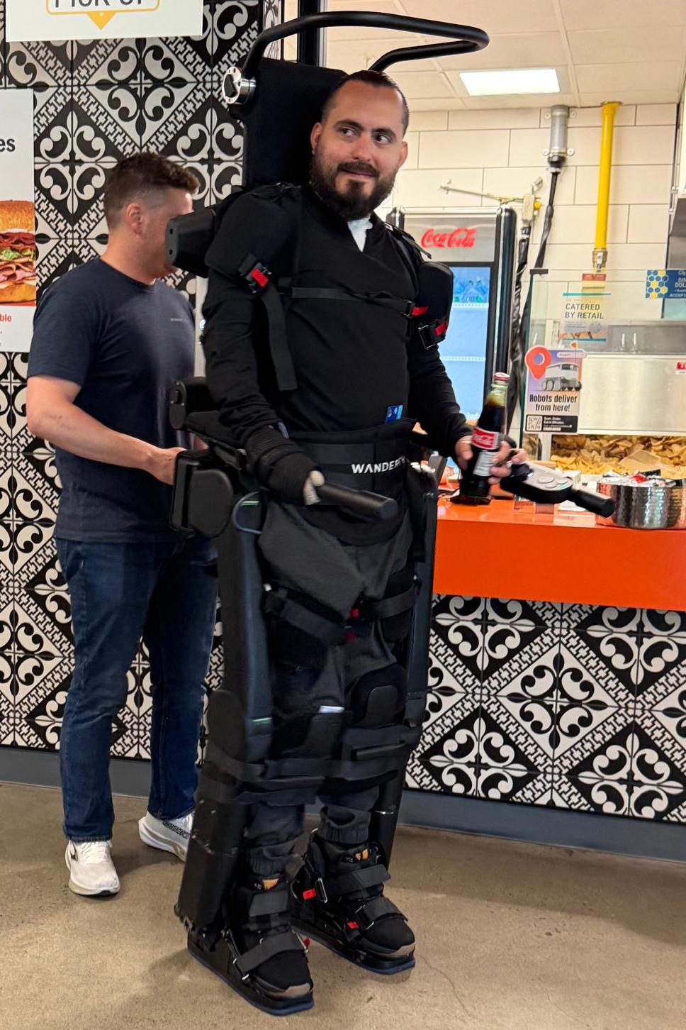 Ignacio Montoya navigates the Student Center in a robotic walking exoskeleton.