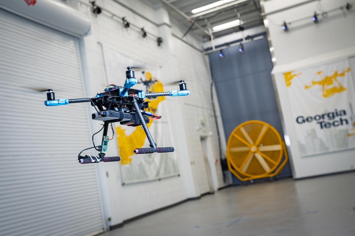 a closeup of a drone in a flight space with a garage door and fan in the background
