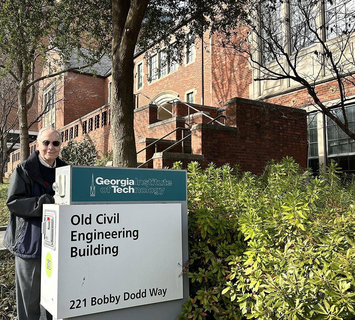 Ken Grundborg poses with the sign for the Old Civil Engineering Building at Georgia Tech.