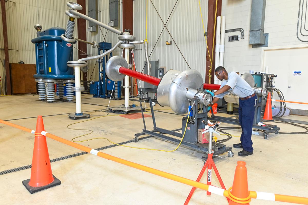 a person in a warehouse works with a section of cable