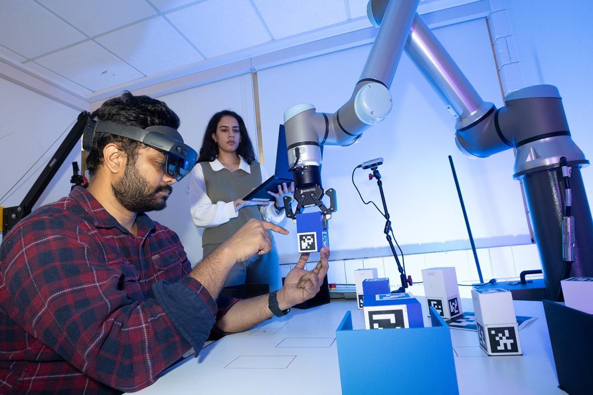 a person interacts with a robotic arm