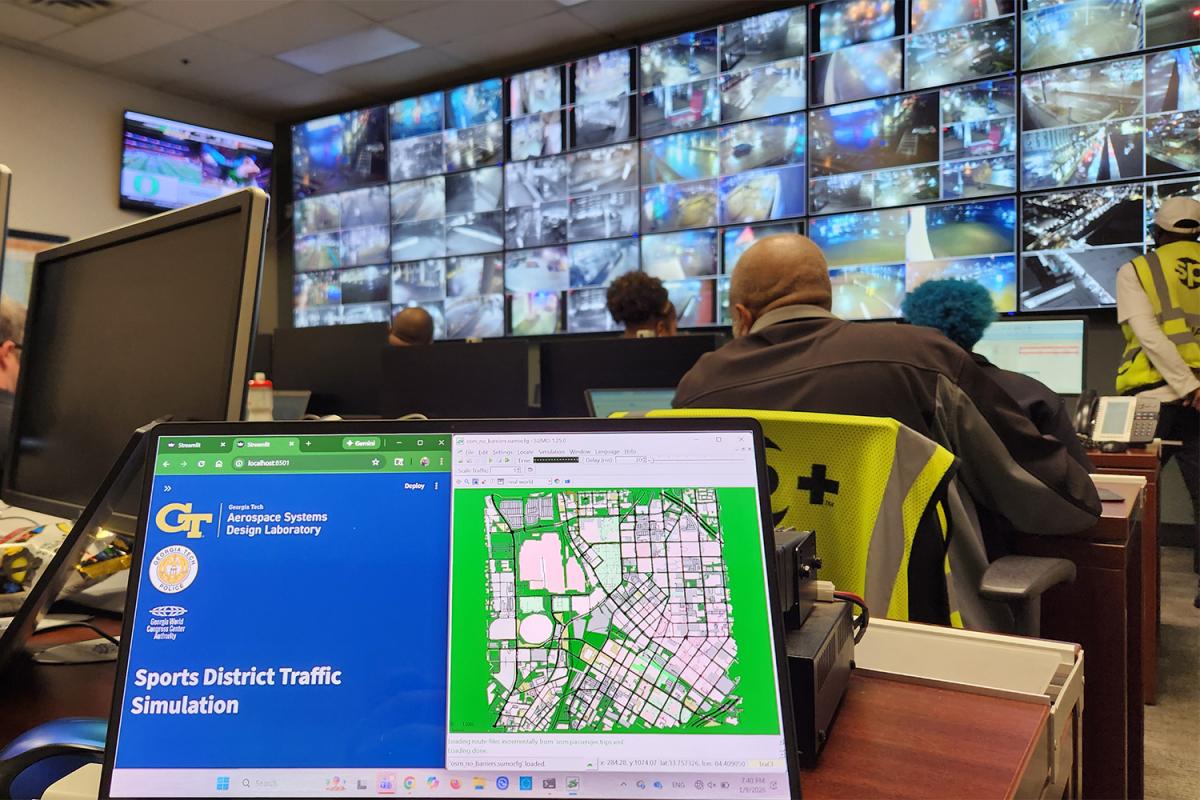 a closeup of a map on a laptop with a wall of camera feeds in the background