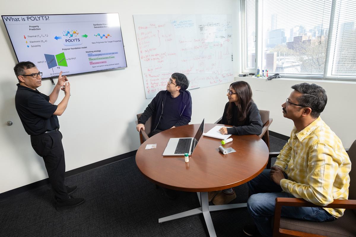 Rampi Ramprasad and three members of his research team discuss their AI models for generative polymer design in his office.
