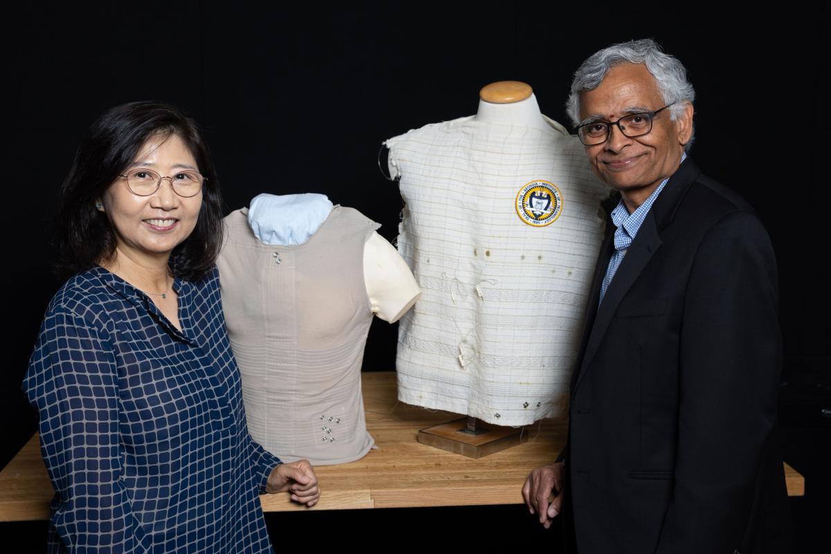 two people standing in front of shirts on mannequins