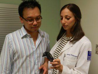 Wilbur Lam and Kathryn Rappaport look at a smartphone with the Remotoscope attachment.