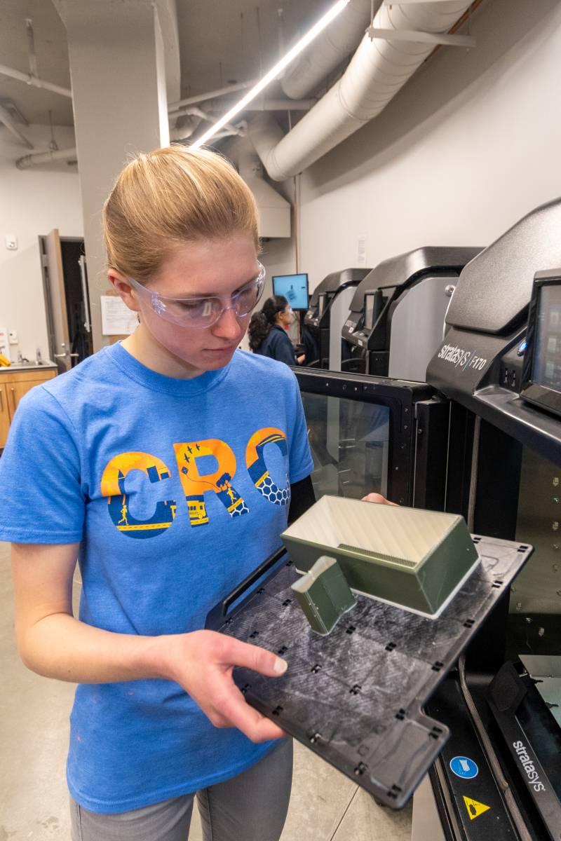 A student works on a project at a 3D printer