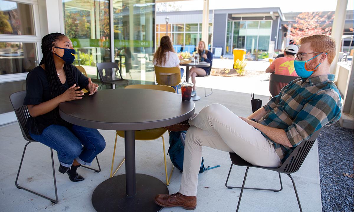 prof and student having coffee outside