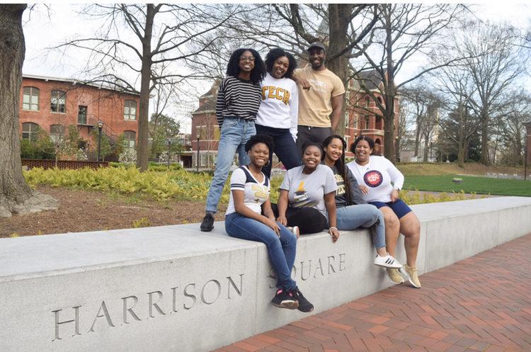 Quinnell and the Black Student Recruitment Team sitting on a wall