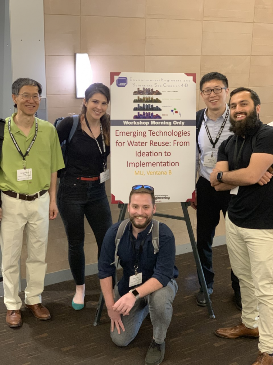 Chen and team posed in front of a poster (photo)